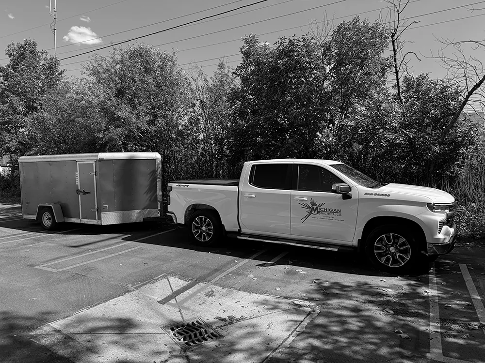 michigan electrical company truck with trailer in parking lot